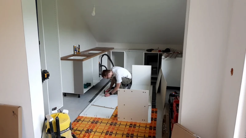Targeted kitchen renovation showing new cabinets, backsplash, and countertop installed while preserving existing layout